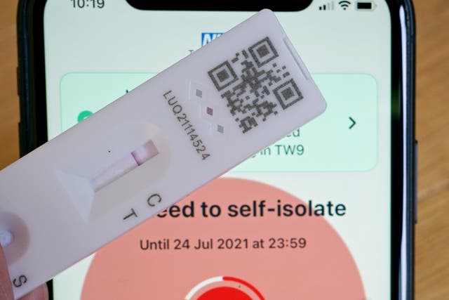 <p>A negative lateral flow test next to advice from the NHS Covid app to self-isolate</p>