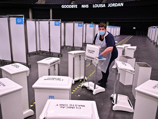 <p>An NHS worker gathers clinical waste bins as Scotland’s temporary NHS Louisa Jordan site is shut down</p>