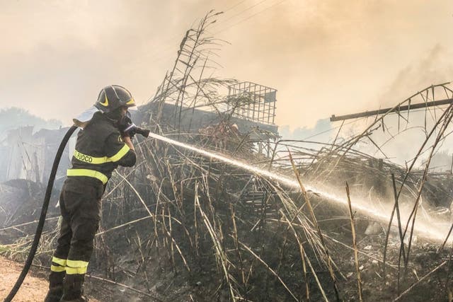 <p>A firefighter battles the flames near Santu Lussurgiu in Sardinia</p>