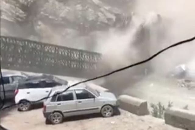 <p>Terrifying video footage shows rocks rolling down in a landslide and hitting cars and a bridge that plunges into the river </p>