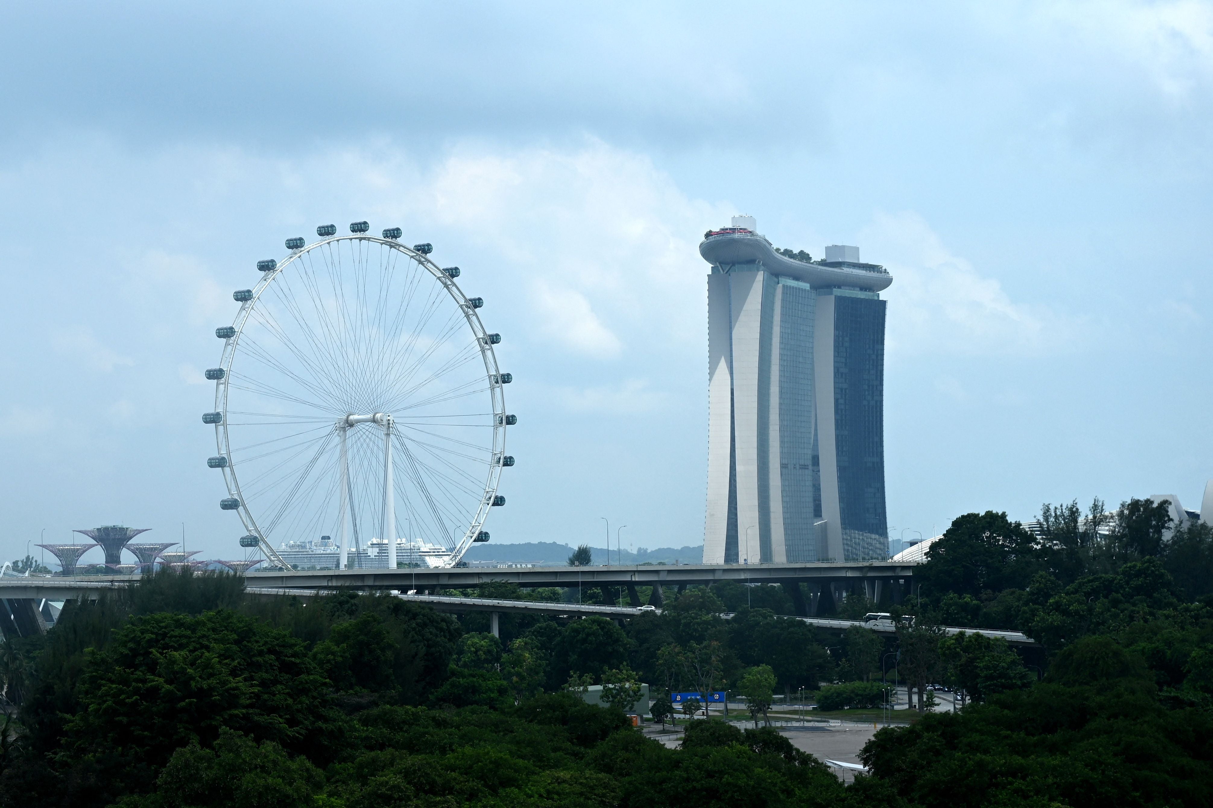 A representational image of Singapore. A general view shows the Singapore Flyer observation wheel (L) and the Marina Bay Sands hotel (R) in Singapore on 16 July 2021