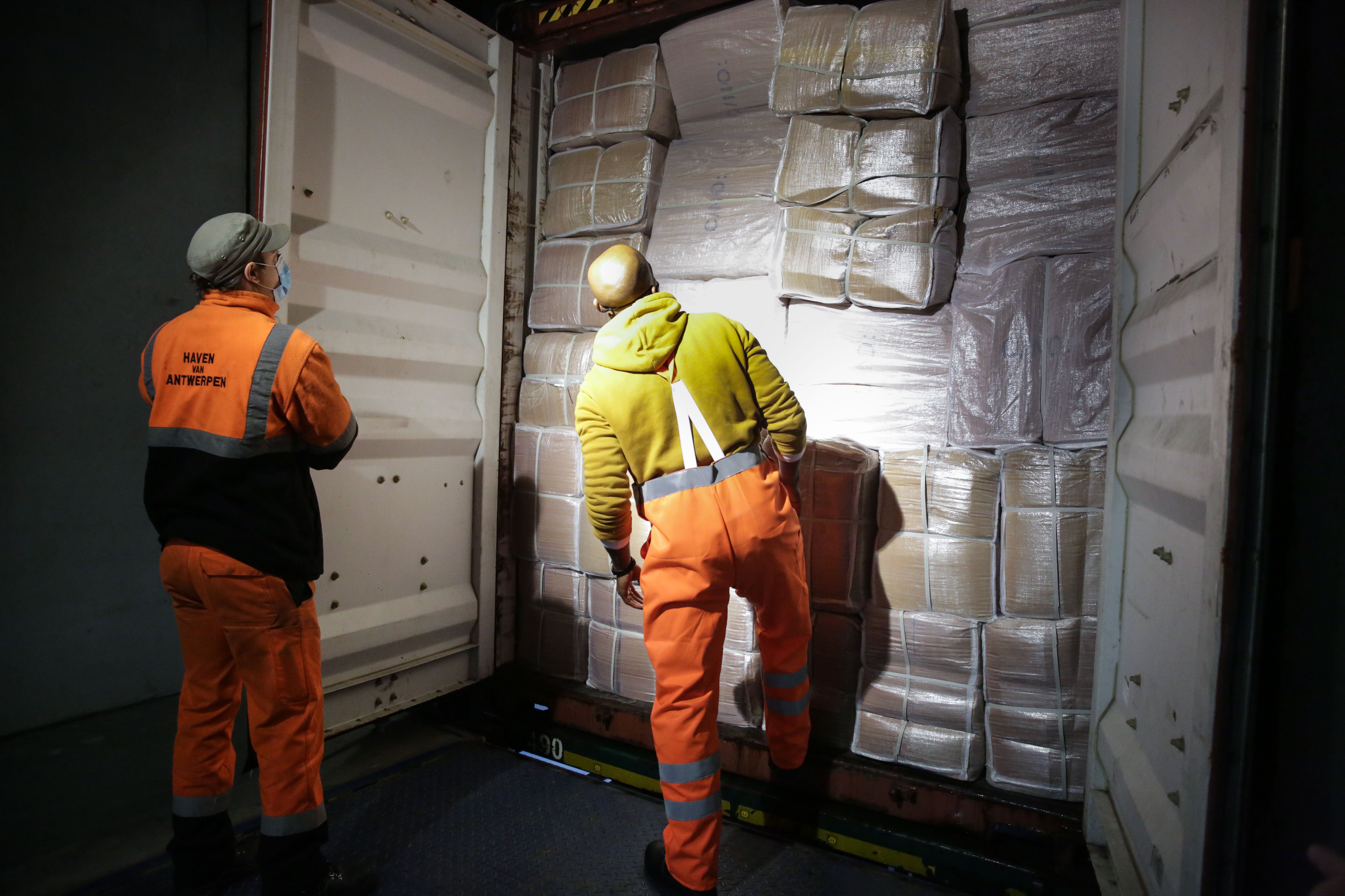 Dock workers in Antwerp checking a van at customs to verify its load