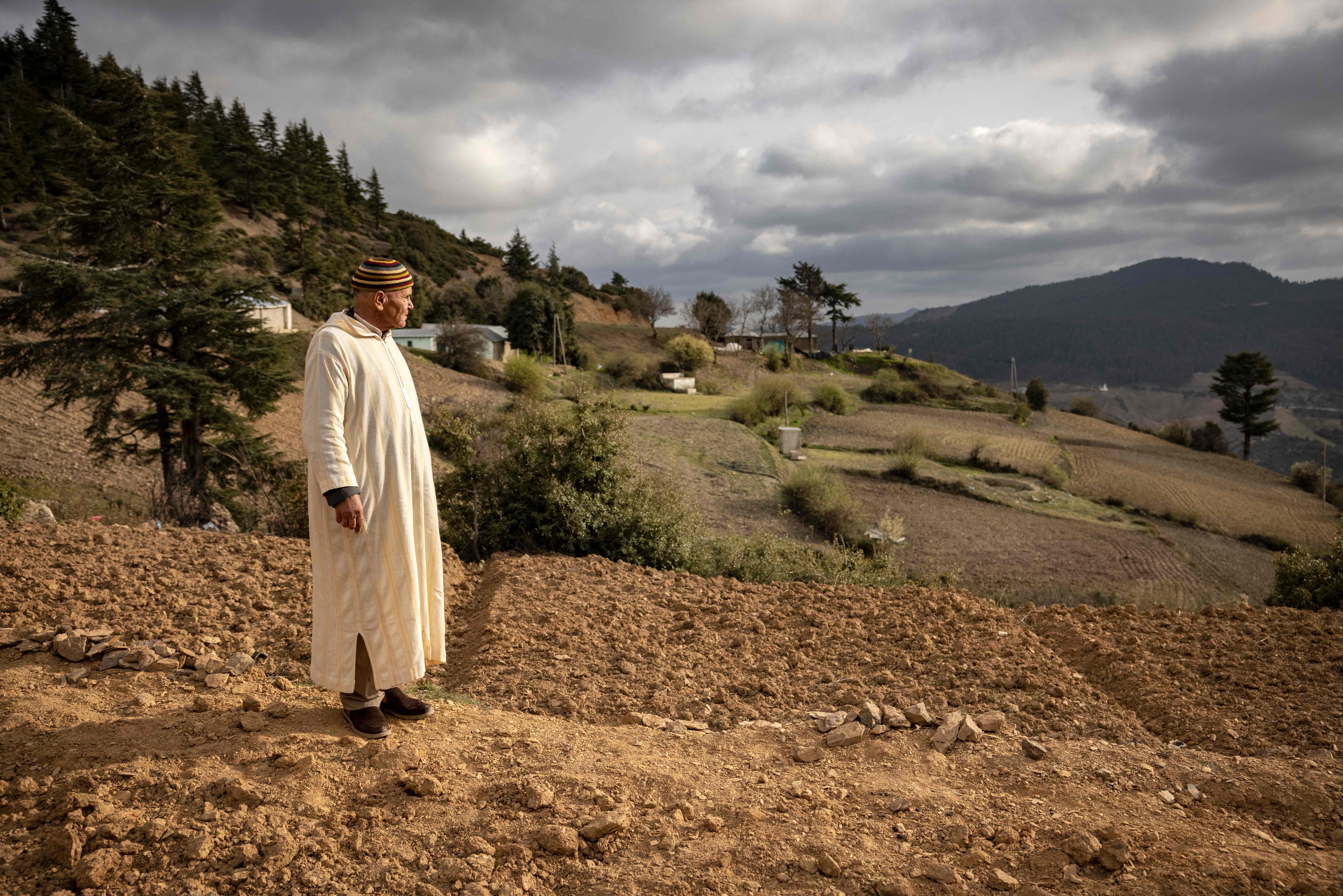 A Moroccan farmer in front of a cannabis field at the foot of the underdeveloped and mountainous region of the Rif