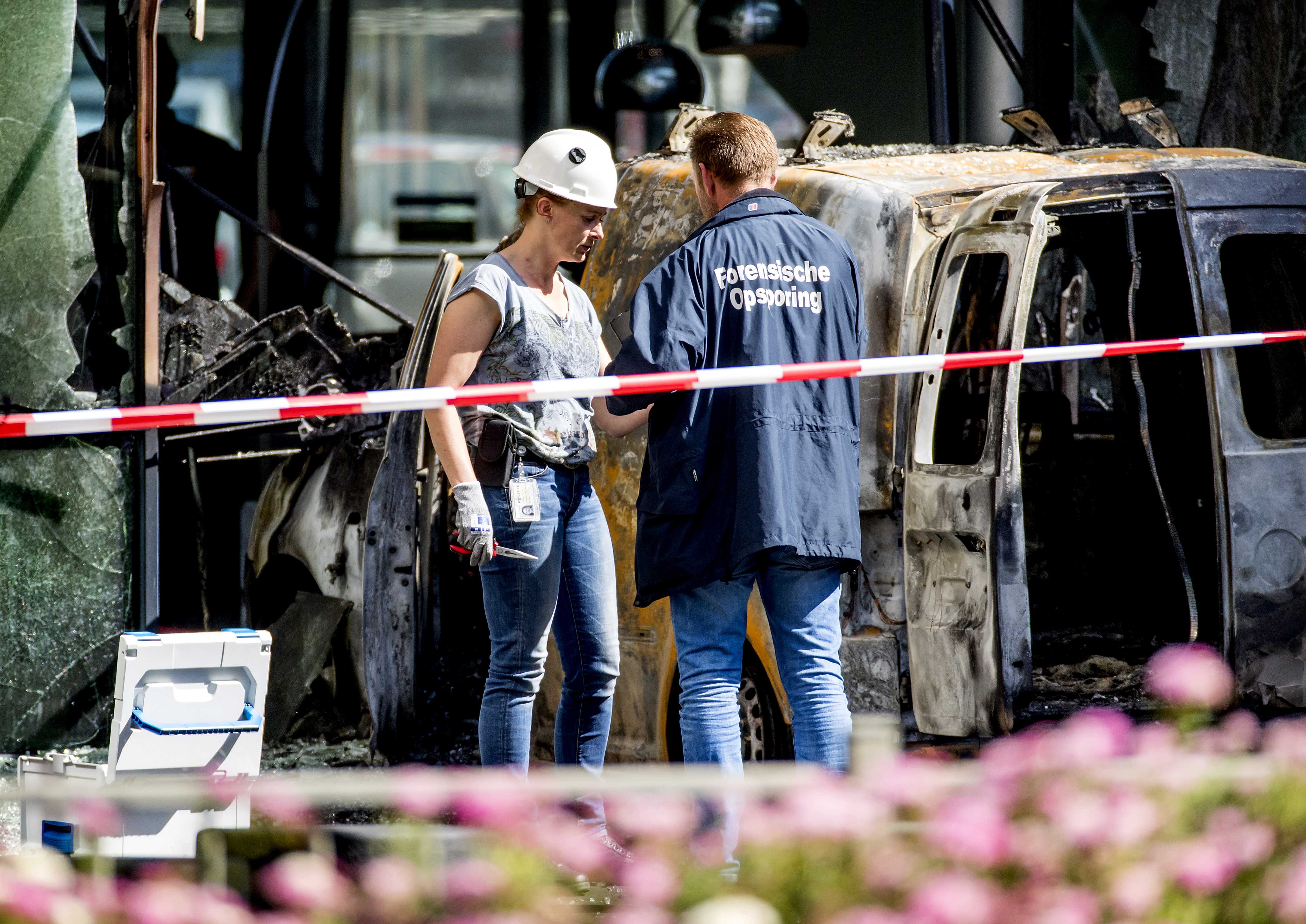 Police officers at the scene of De Telegraaf newspaper, where a van was driven through the front doors of the building and set on fire in June 2018