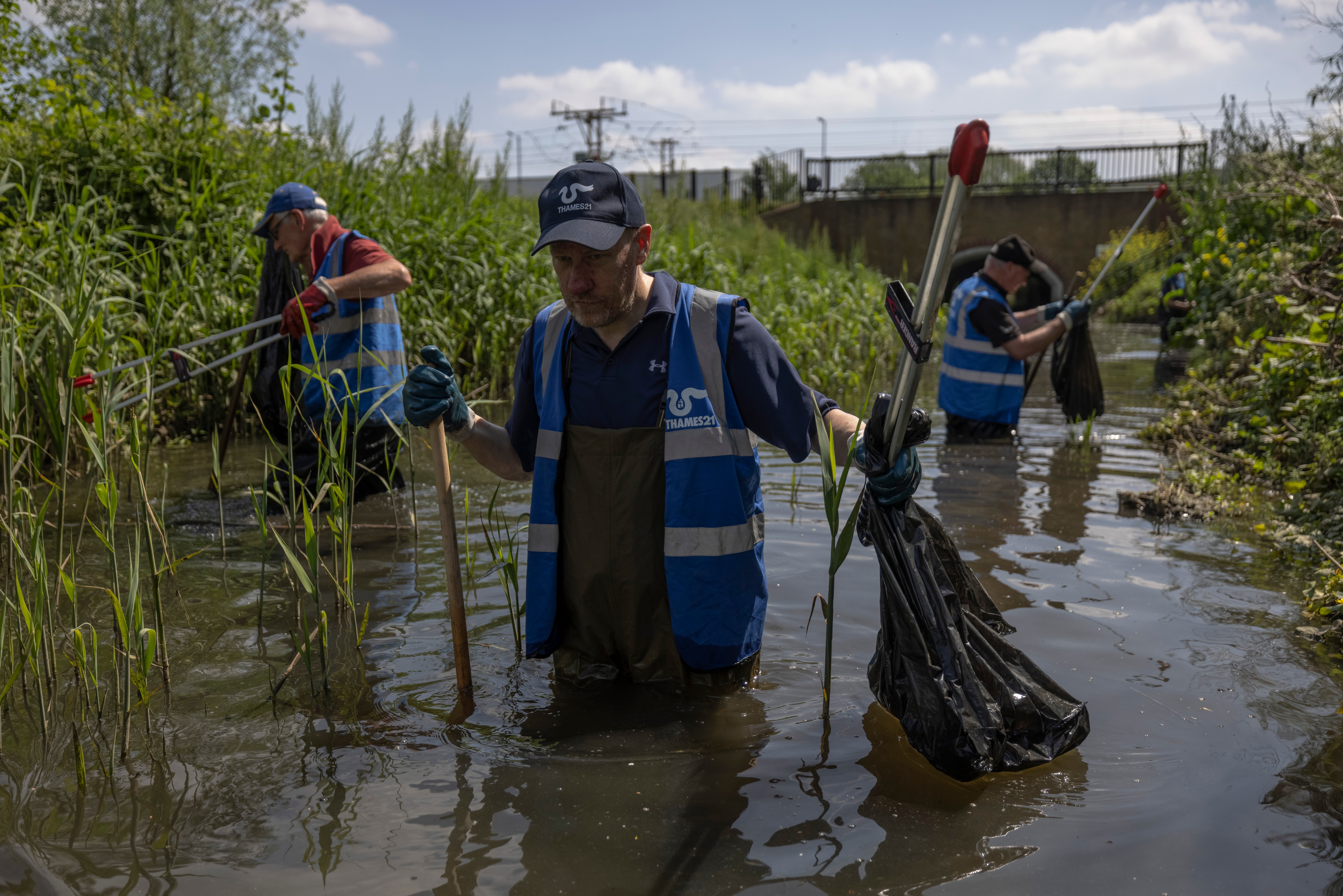 Volunteers on a river clean-up to remove litter and invasive plants in London