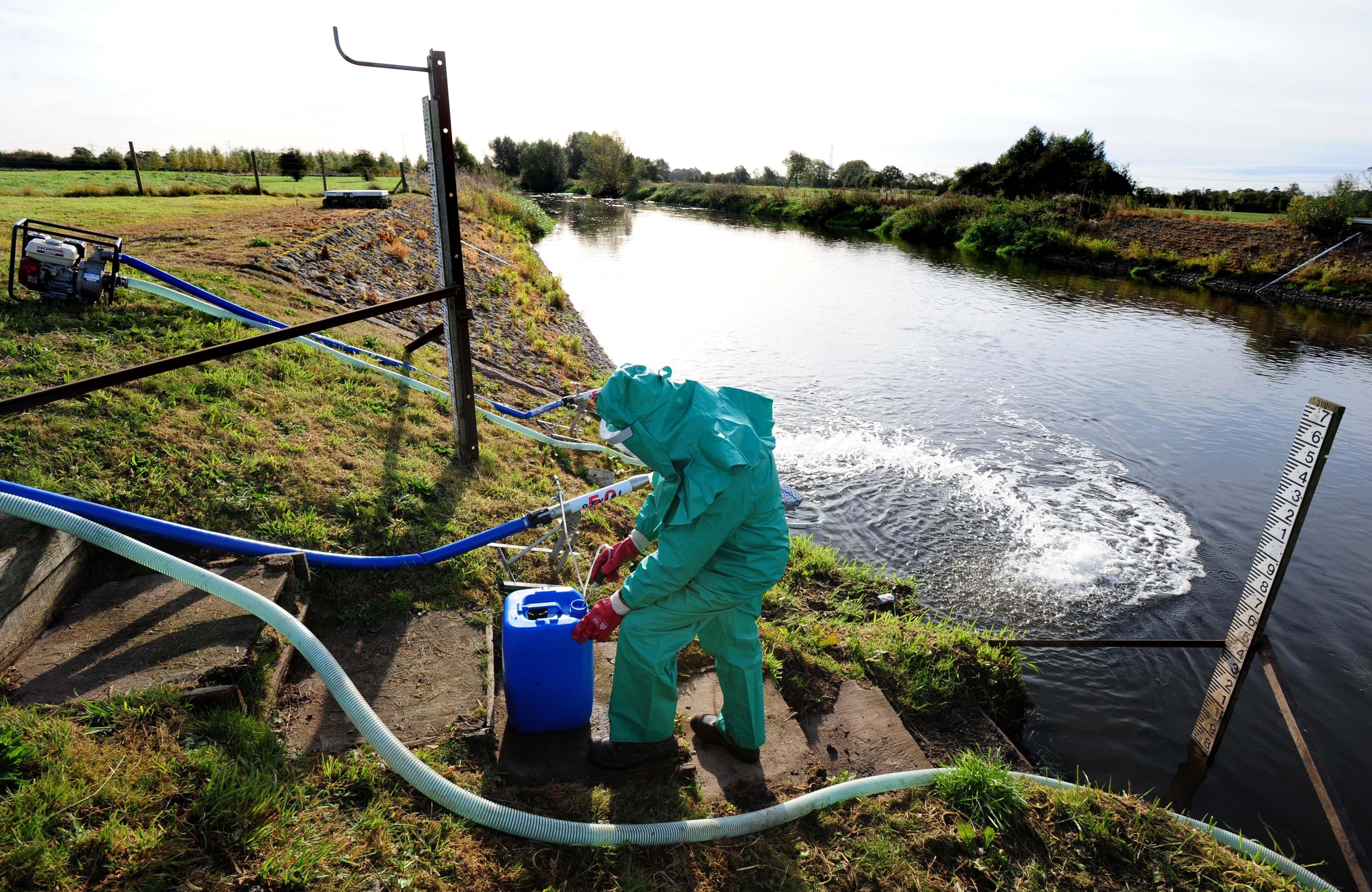 An Environment Agency worker treats the River Trent at Yoxall, Staffordshire, after it was contaminated with untreated sewage and cyanide