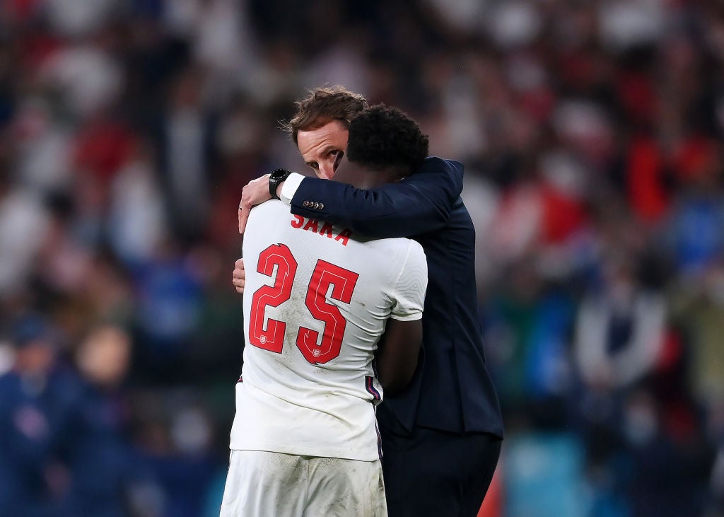 England player Bukayo Saka is consoled by Gareth Southgate after his Euro 2020 penalty