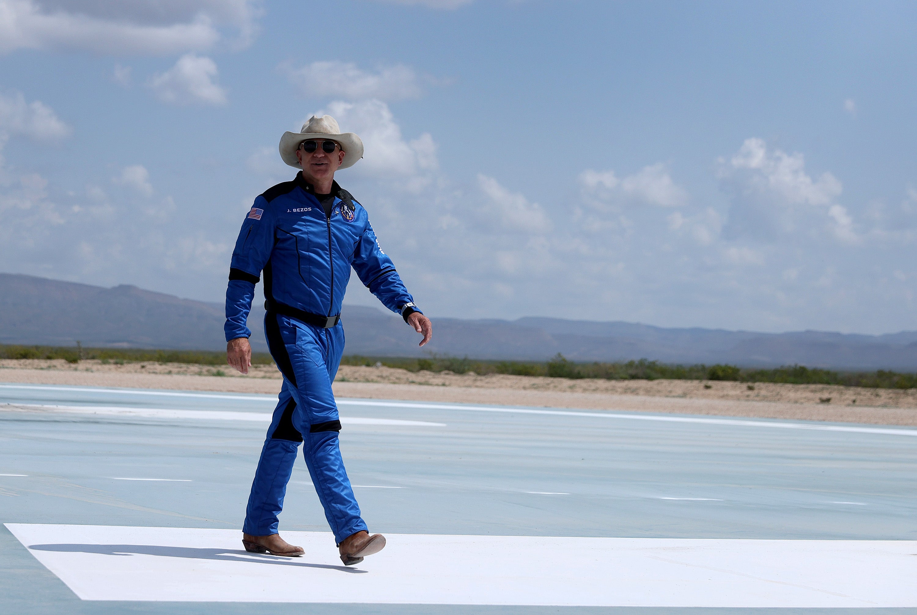 Jeff Bezos walks near Blue Origin’s New Shepard after flying into space