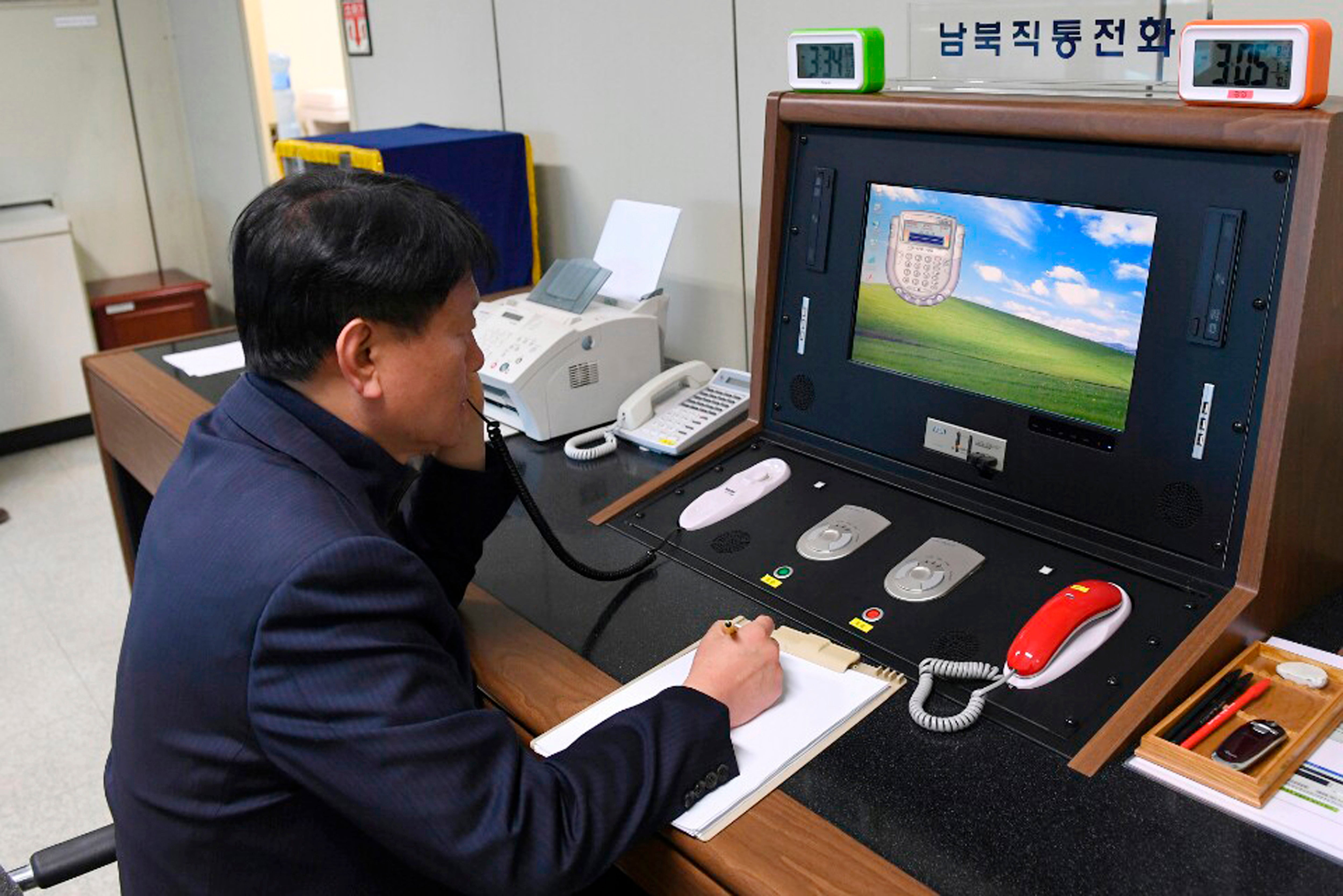 File image: In this 3 January 2018 file photo released by South Korea Unification Ministry, a South Korean government official communicates with a North Korean officer during a phone call on the dedicated communications hotline at the border village of Panmunjom in Paju, South Korea