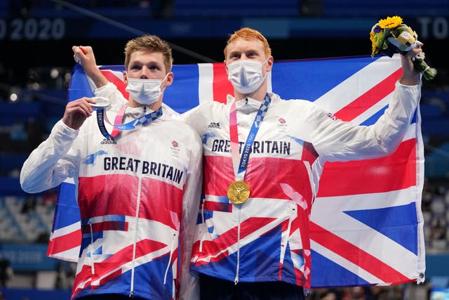 <p>Duncan Scott and Tom Dean celebrate their medals</p>