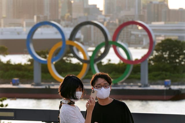 <p>A couple takes a commemorating selfie with the Olympic Ring Monument at Odaiba in Tokyo</p>