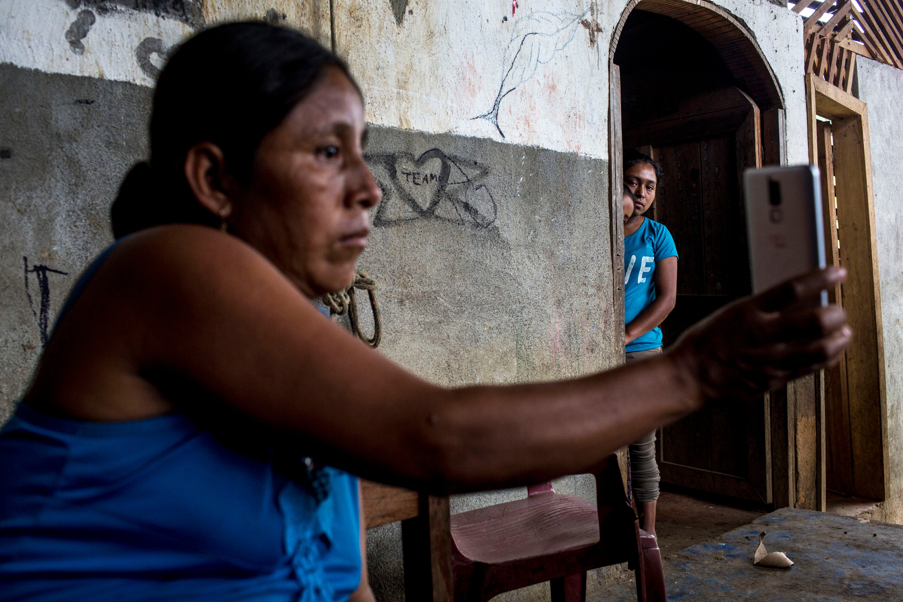 A mother who is separated from her daughter shows a photo of the girl