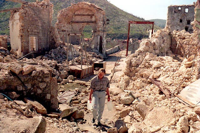 <p>A girl carries jugs of water down a street destroyed by Croat shelling near the old bridge in the eastern (Muslim) part of Mostar, 30 March 1994</p>