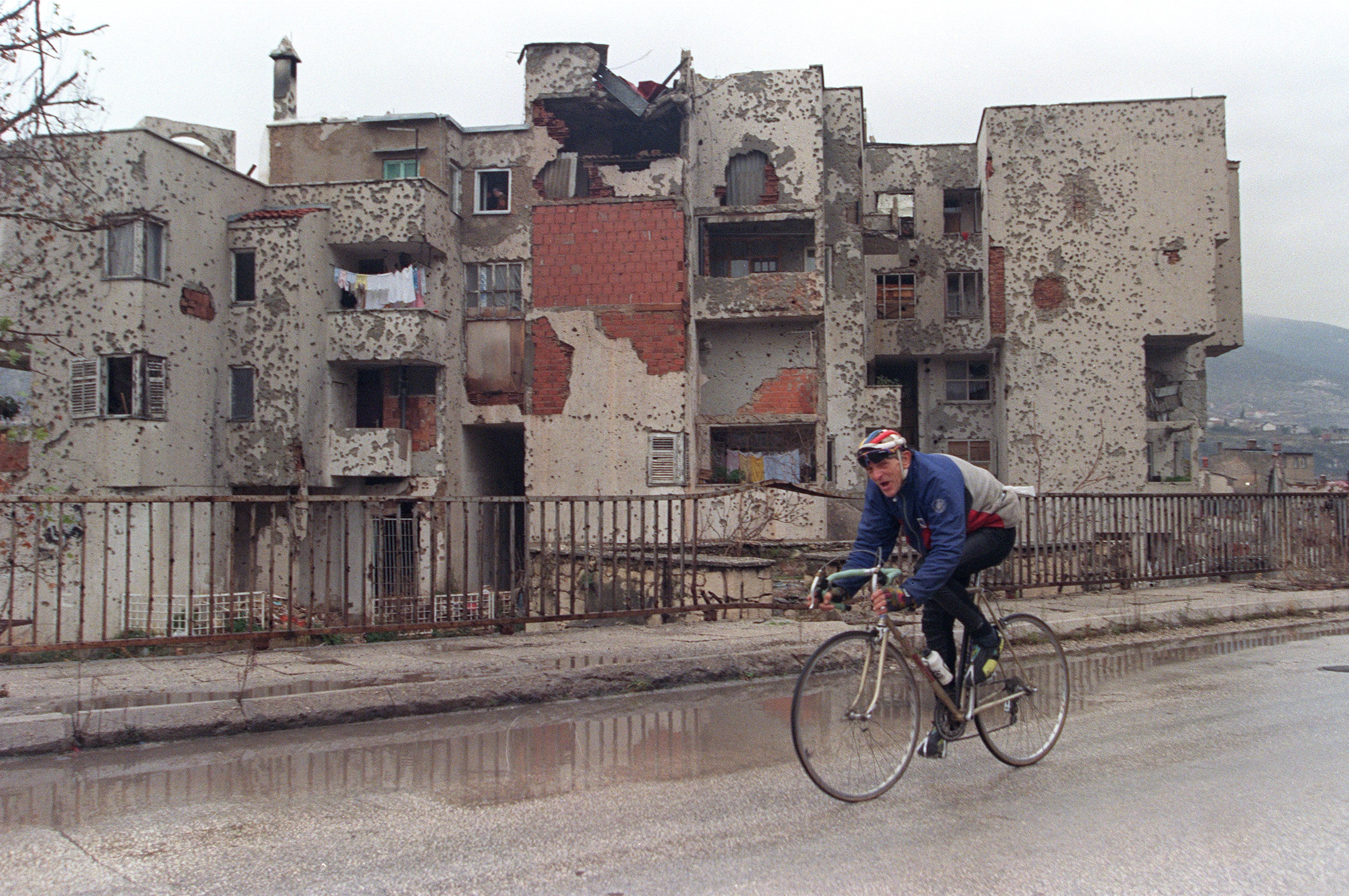 A cyclist rides past destroyed building in Mostar, 18 December 1995