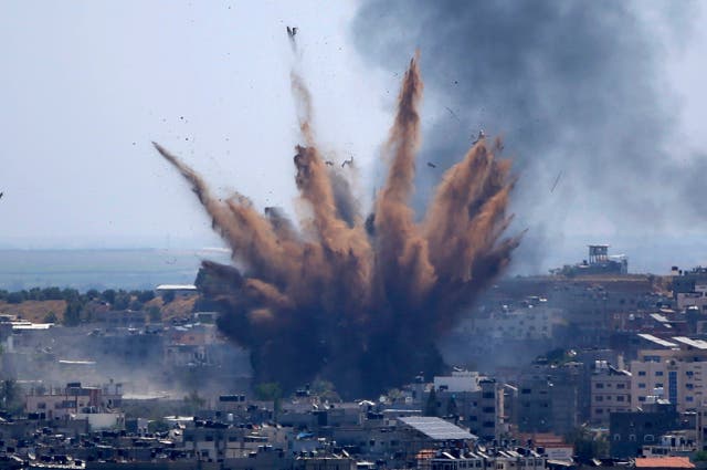 <p>Smoke rises following Israeli airstrikes on a building in Gaza City in May</p>