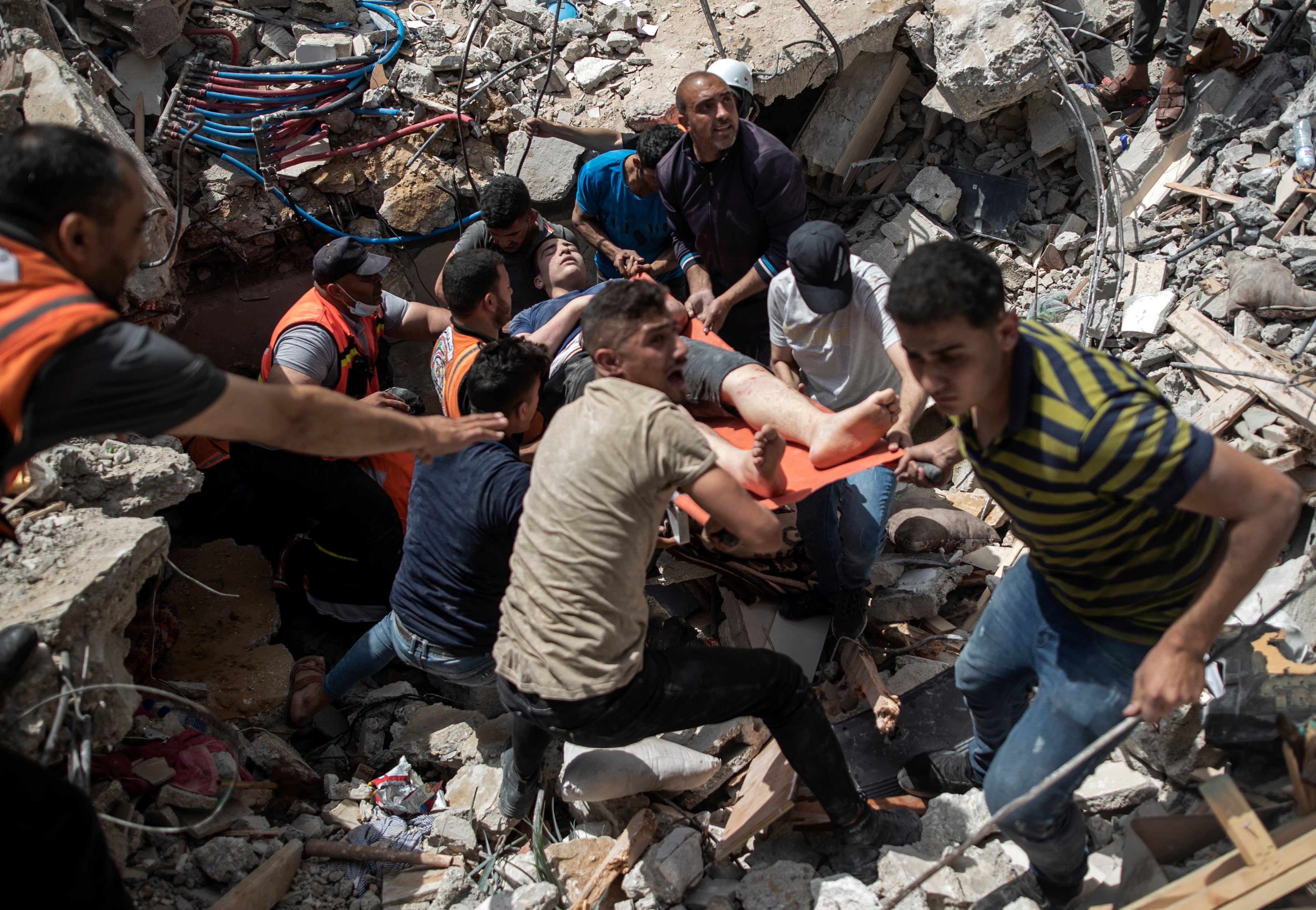 Palestinian rescue a survivor from under the rubble of a destroyed residential building following deadly Israeli airstrikes in Gaza Cit