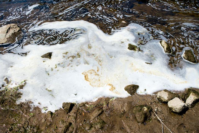 <p>In this 7 June 2018 file photo, PFAS, or perfluoroalkyl and polyfluoroalkyl substances, foam gathers at the the Van Etten Creek dam in Oscoda Township, Michigan </p>