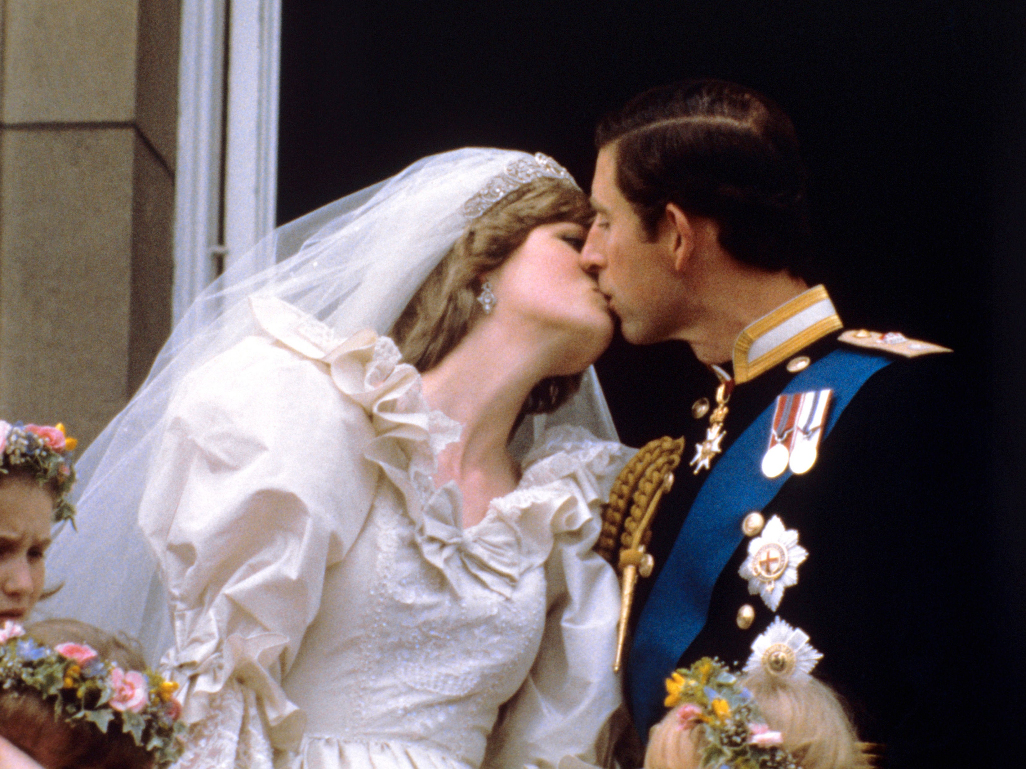 <p>The newly married Prince and Princess of Wales (formerly Lady Diana Spencer) kissing on the balcony of Buckingham Palace after their wedding ceremony at St. Paul’s cathedral in 1981</p>