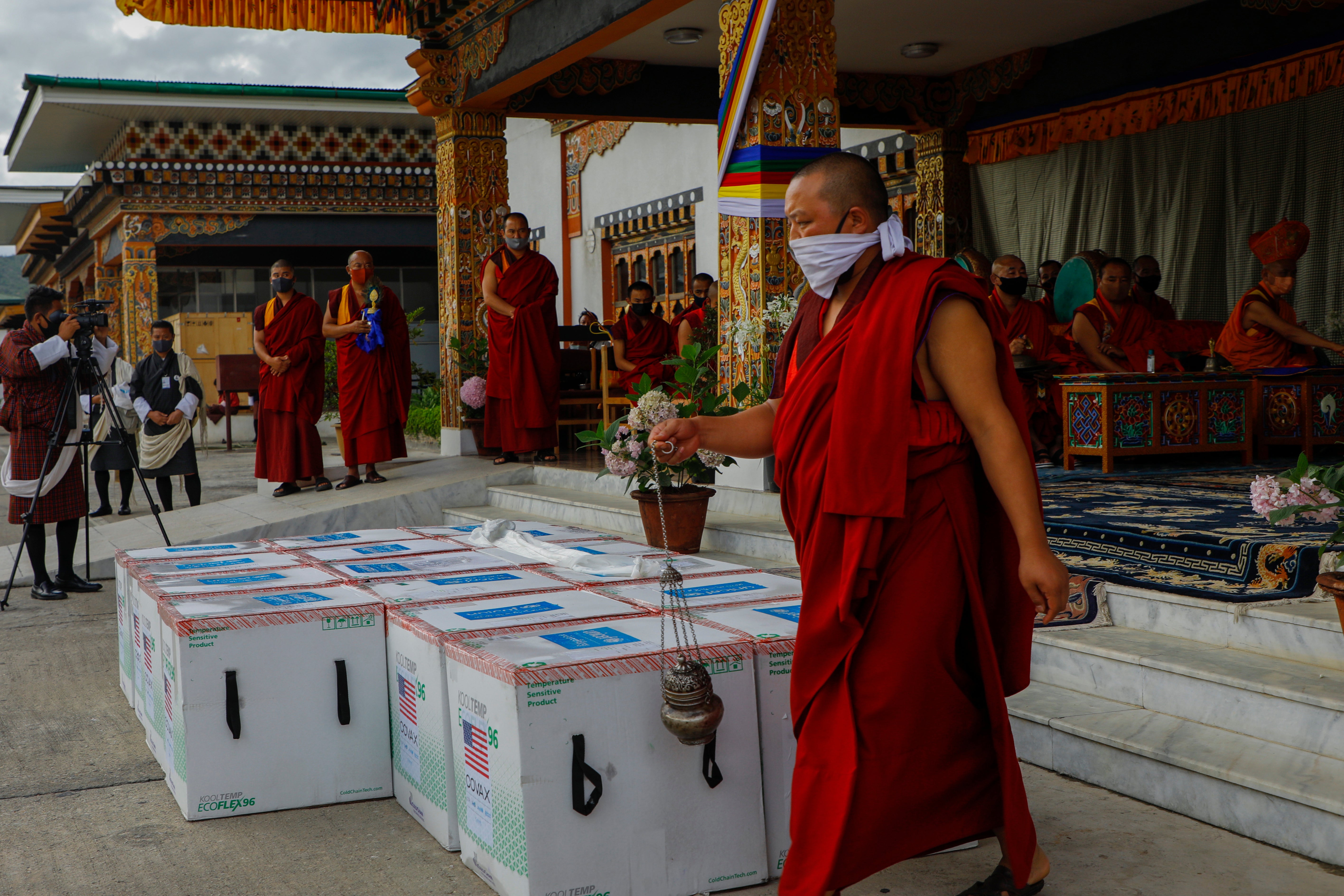 This photograph provided by Unicef shows monks from Paro’s monastic body performing a ritual as 500,000 doses of Moderna vaccine gifted from the United States arrive at Paro International