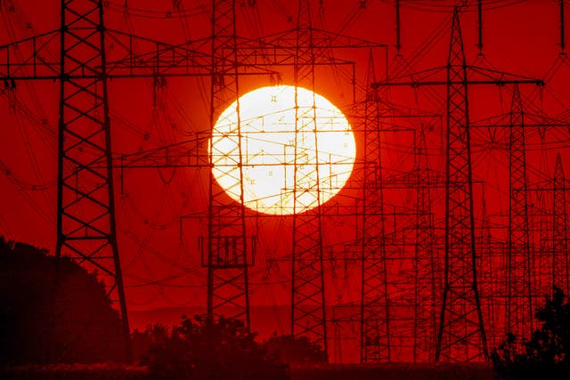 <p>The sun sets behind power lines in Frankfurt, Germany</p>