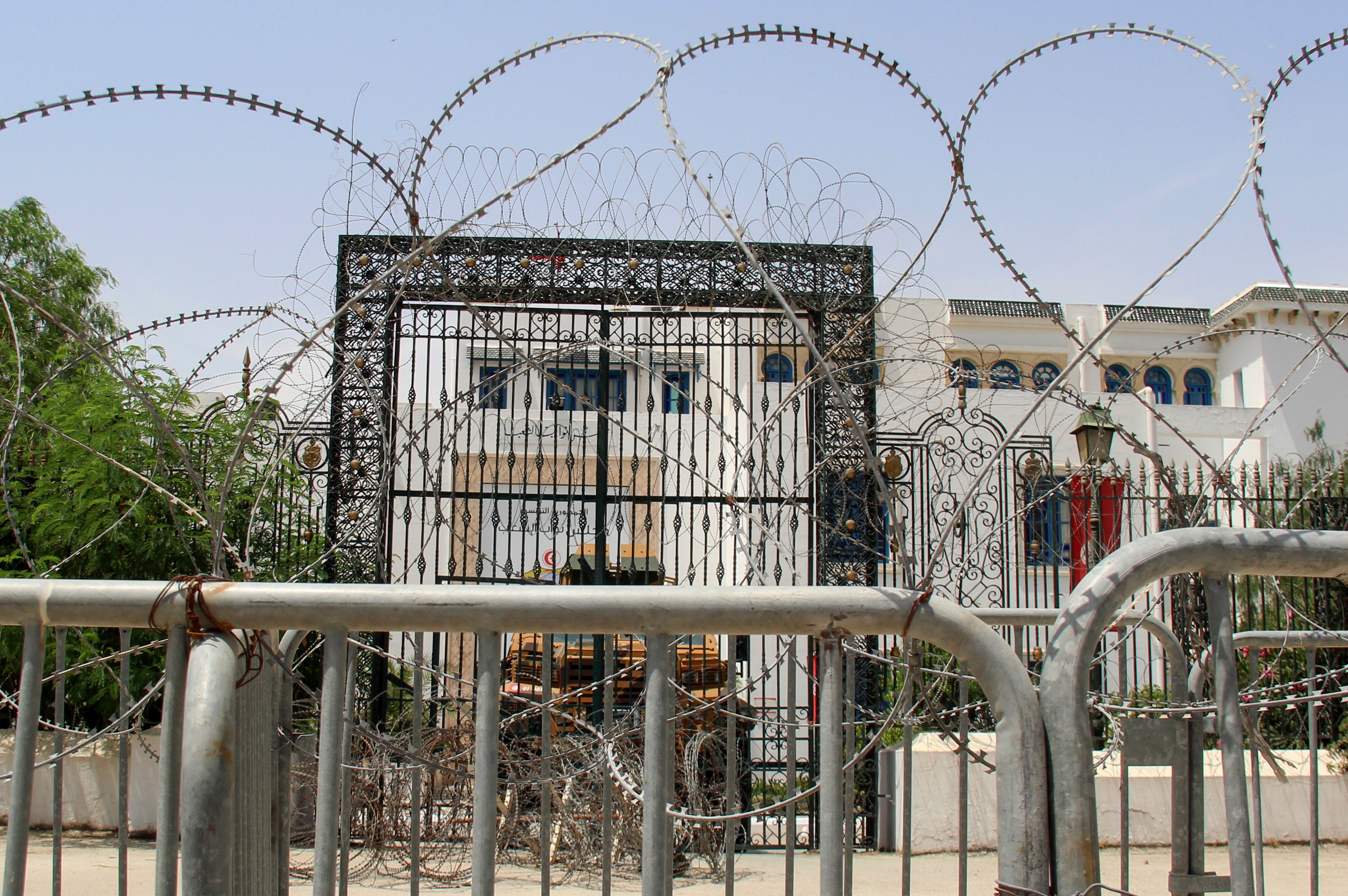 Barbed wire and a military armored personnel carrier block a side entrance of the Tunisian parliament