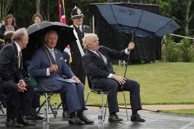 <p>Prince Charles and Boris Johnson battle rain at the opening of a police memorial on Wednesday</p>