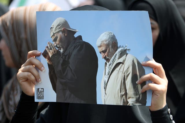 <p>A supporter of Iran-backed Iraqi Shiite armed groups popular mobilisation forces carries the pictures of slain Abu Mahdi al-Muhandis and General Qassem Soleimani during a symbolic funeral</p>