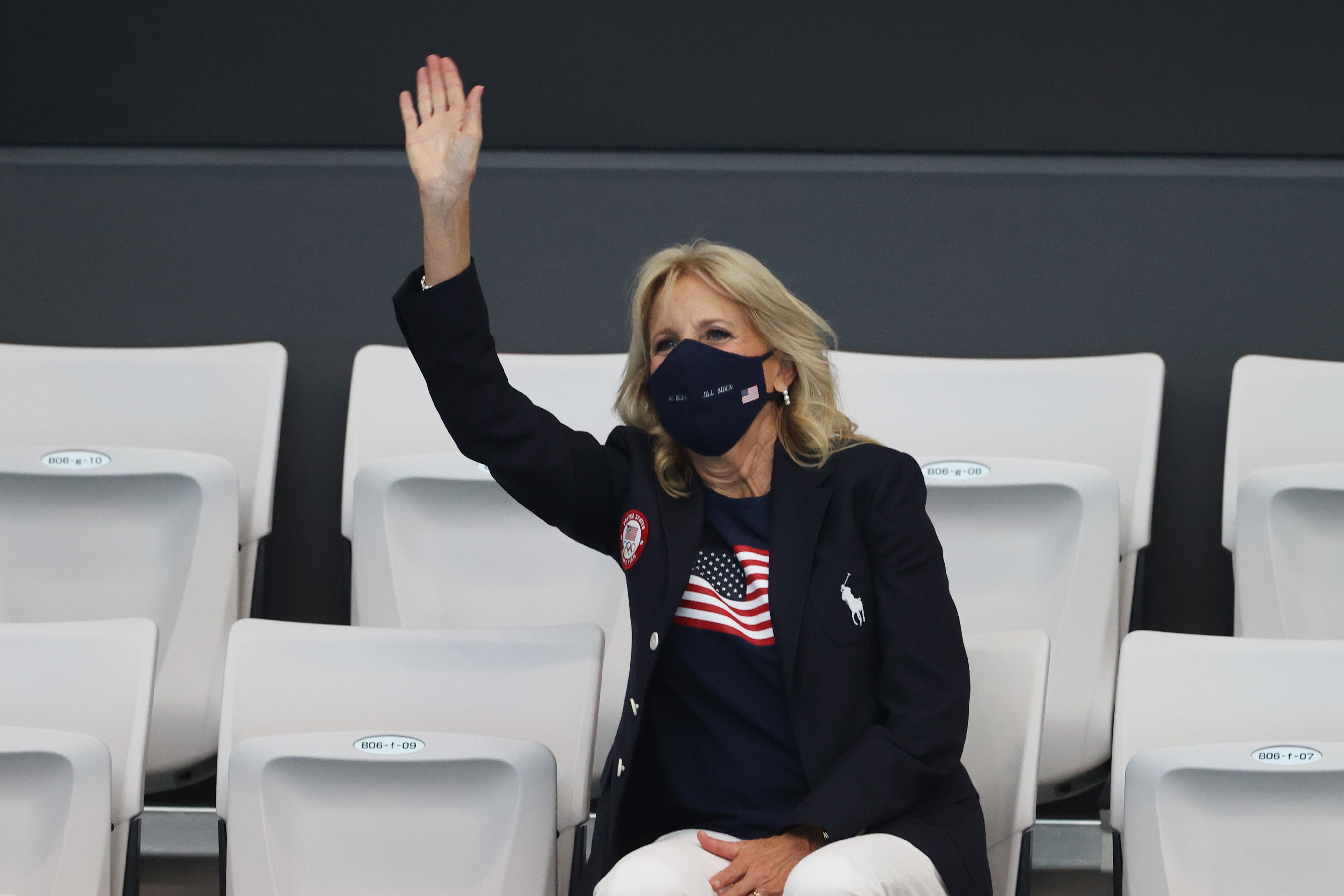 Biden wears the Ralph Lauren navy jacket and trousers that are part of the official US Olympic Team uniform to the Tokyo Aquatics Centre