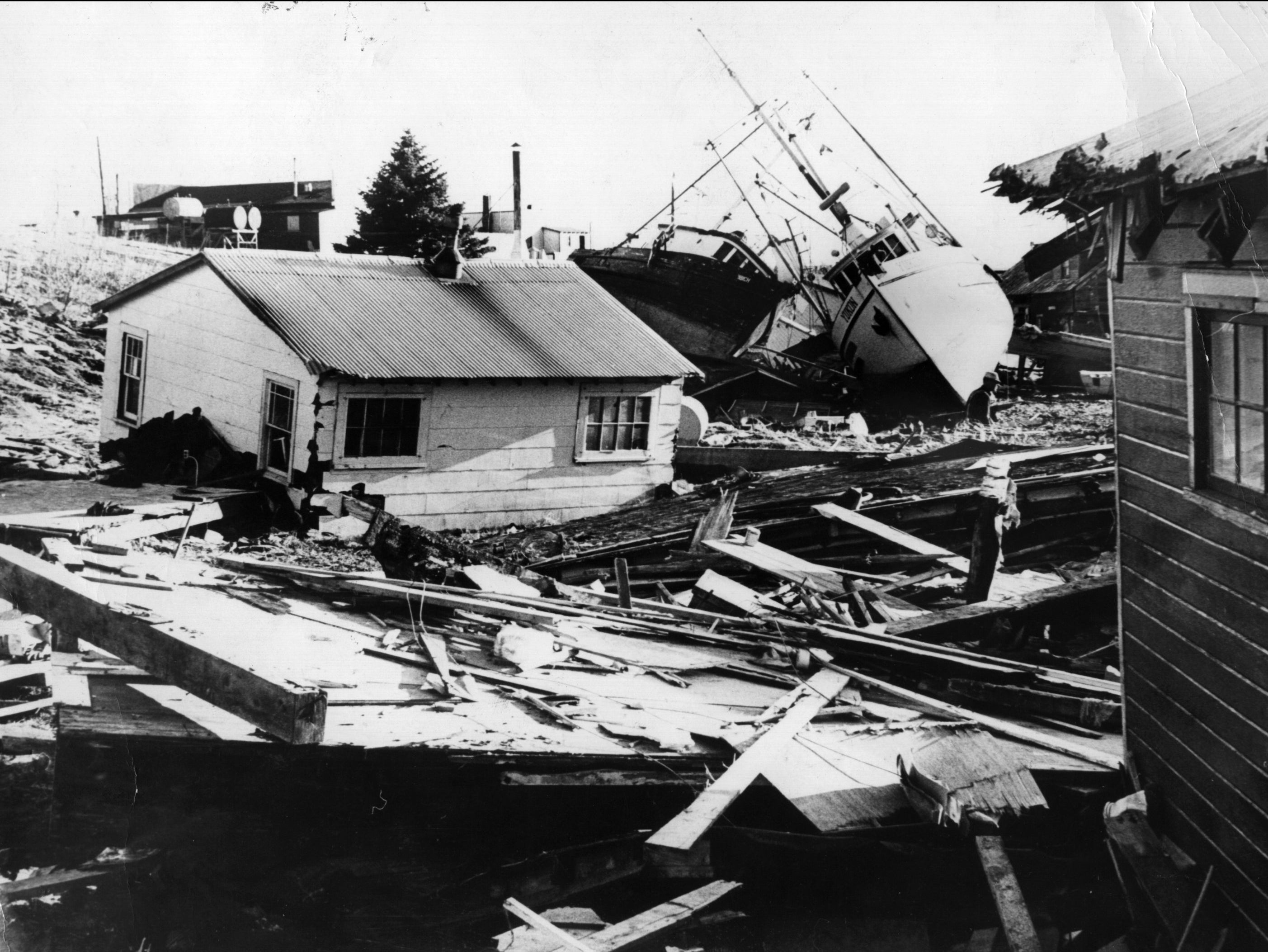A small fishing village on Kodiak Island in Alaska littered with debris from houses and boats after an earthquake and tidal wave struck it on 4 April 1964