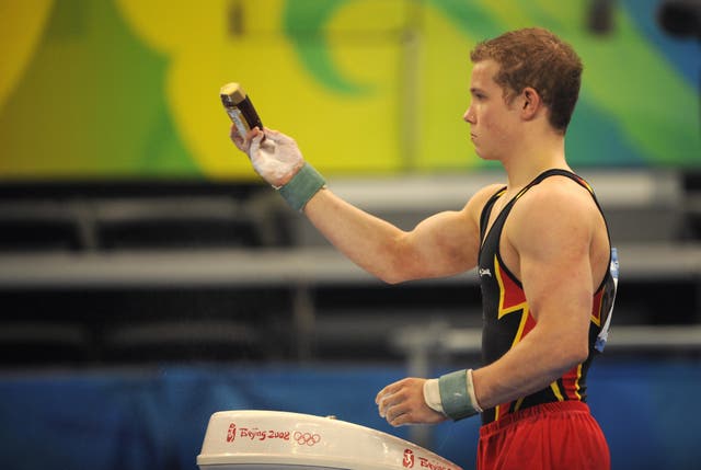 <p>Germany's Fabian Hambuchen holds a bottle of honey as he applies talcum during the men's qualification of the artistic gymnastics event of the Beijing 2008 Olympic Games in Beijing on August 9, 2008</p>