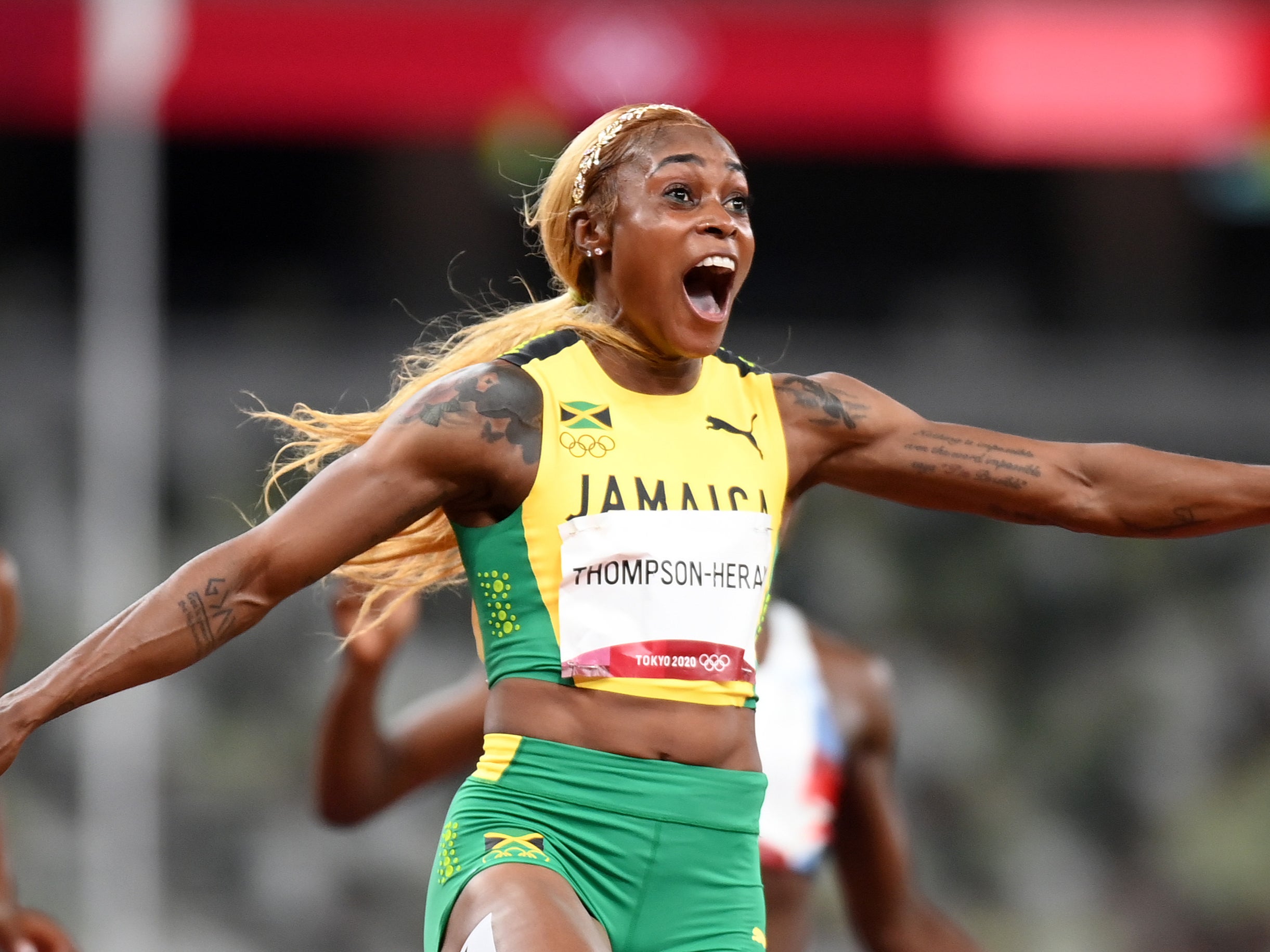 Elaine Thompson-Herah of Team Jamaica crosses the finish line to win the gold medal
