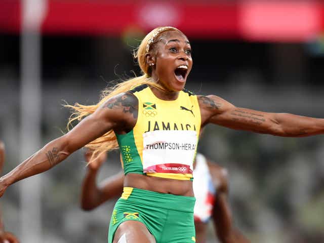 <p>Elaine Thompson-Herah of Team Jamaica crosses the finish line to win the gold medal</p>