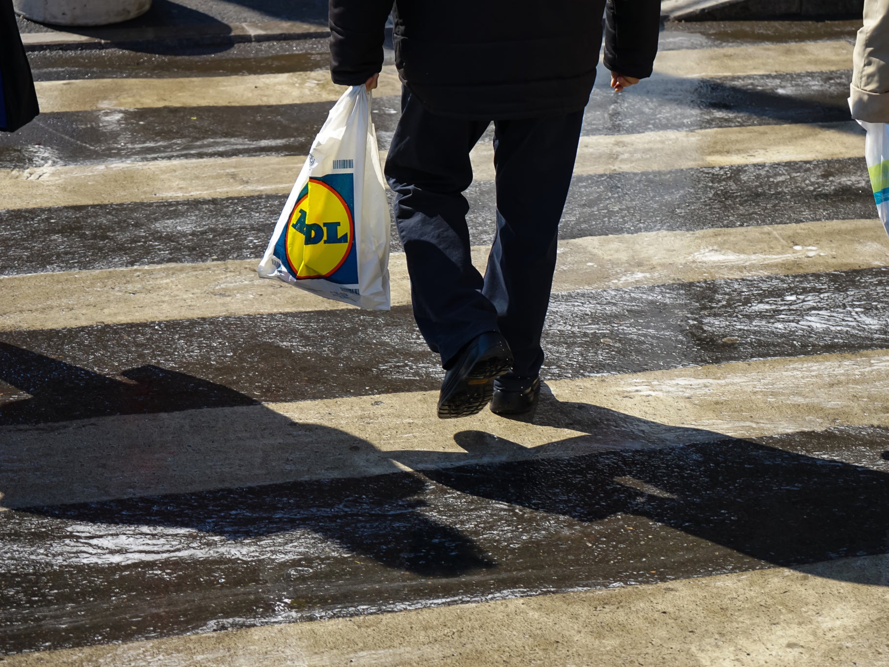 A person carrying a Lidl shopping bag