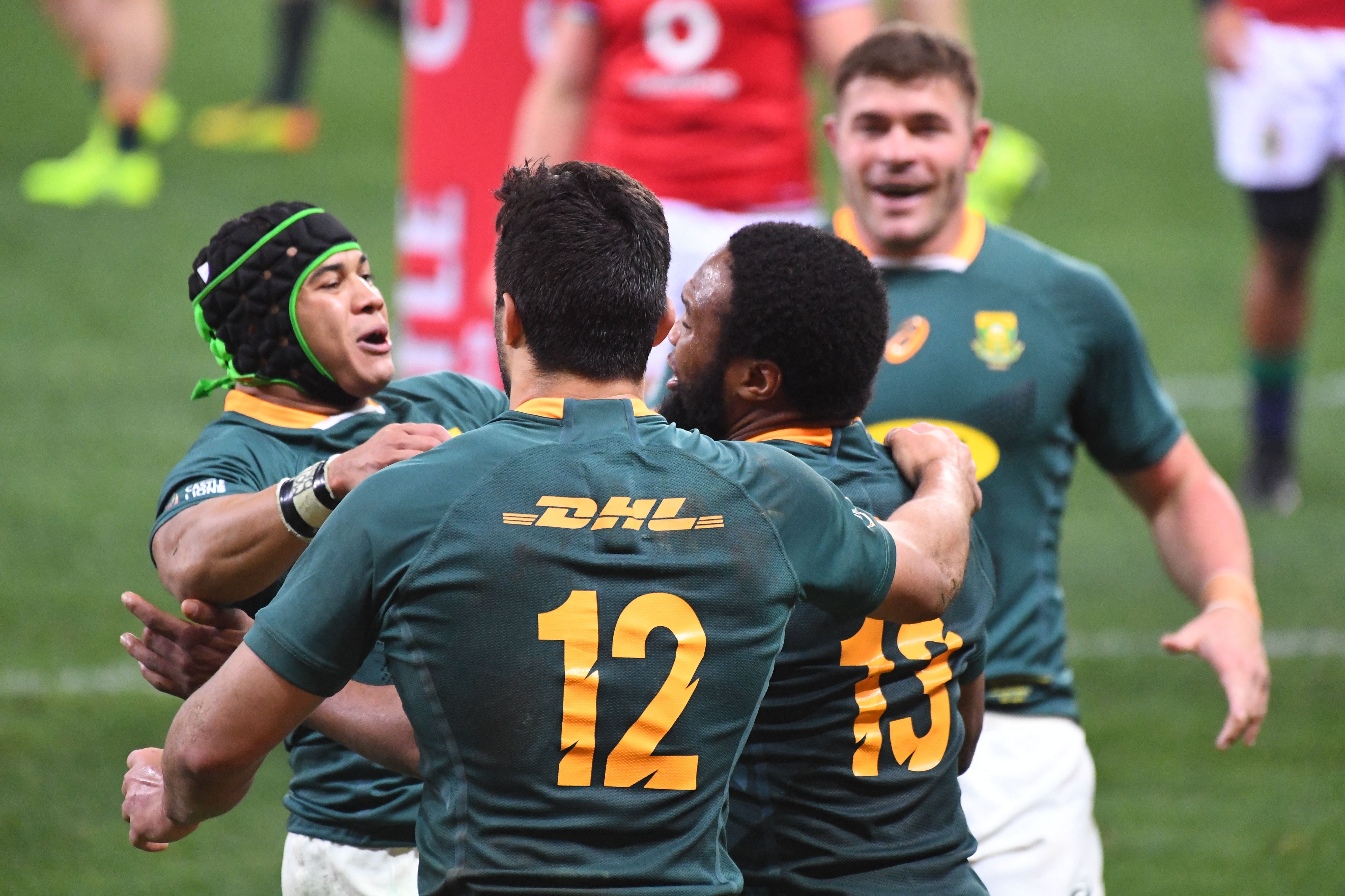 South Africa's center Lukhanyo Am (R) is celebrated by teammates