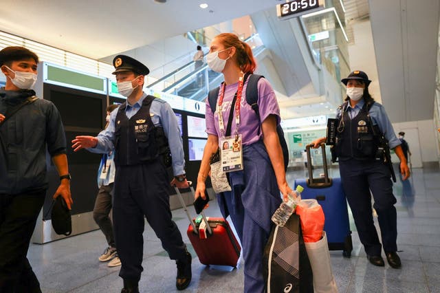 <p>Belarusian athlete Krystsina Tsimanouskaya is escorted by police officers at Haneda international airport in Tokyo</p>