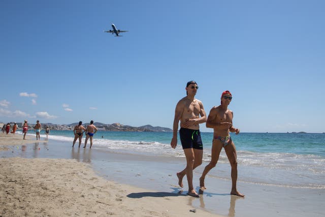 <p>Tourists stroll along d'en Bossa Beach on July 16, 2021 in Ibiza, Spain</p>