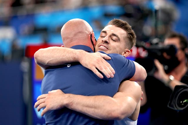 Max Whitlock embraced his coach Scott Hann after defending his Olympic title (Mike Egerton/PA)