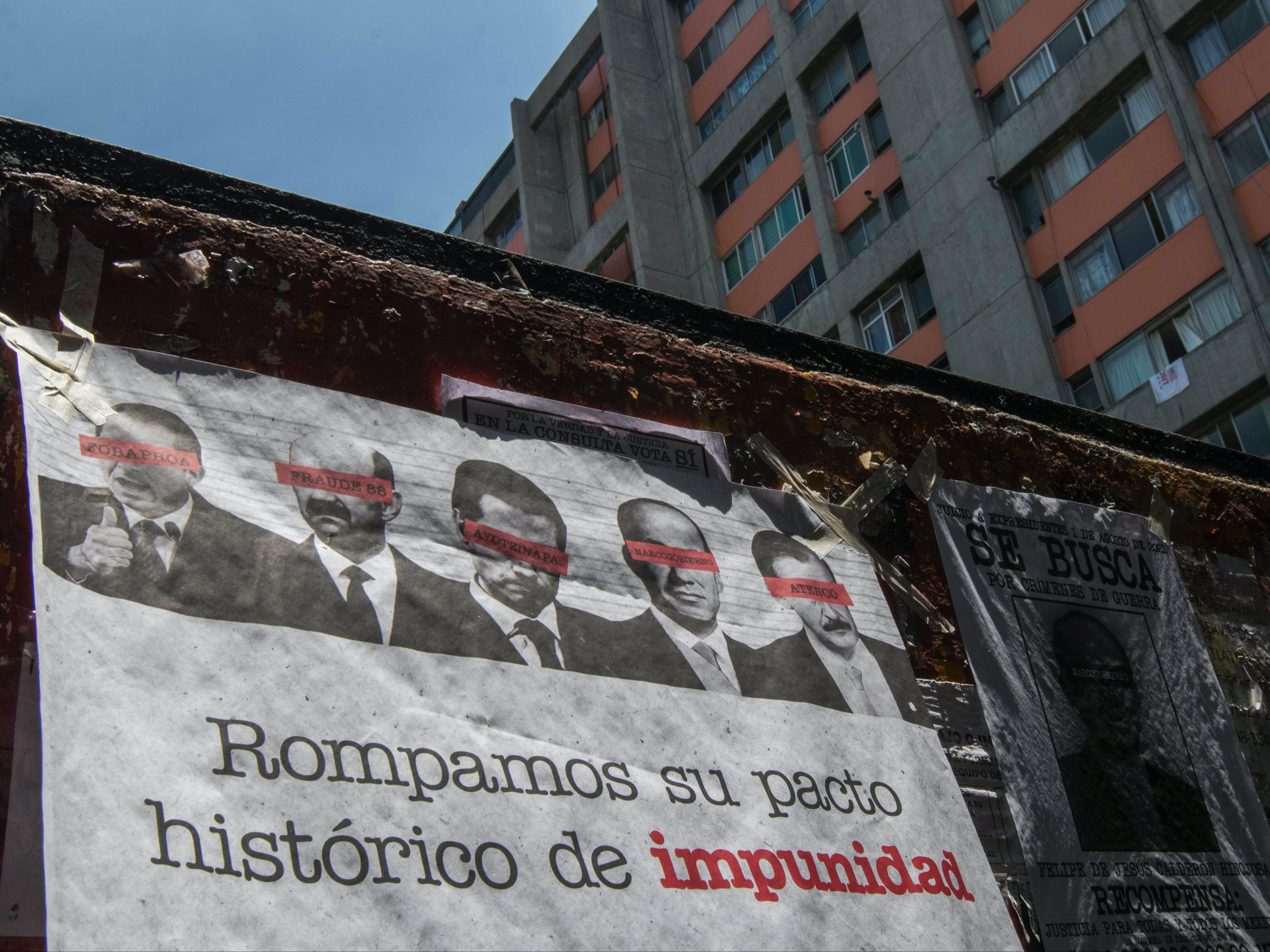 <p>Una manta que muestra imágenes de varios ex presidentes mexicanos, oscureciendo sus ojos con barras rojas y pidiendo a los ciudadanos que participen en un referéndum sobre si deben ser juzgados por sus presuntos crímenes durante su mandato, cuelga de una pared en la Ciudad de México el domingo 1 de agosto de 2021. </p>