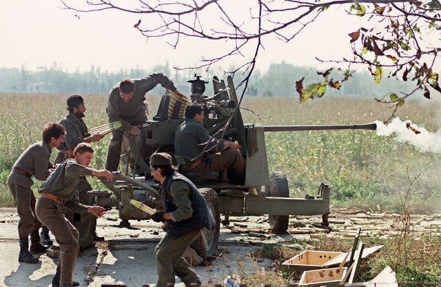 <p>Serb volunteers in Borovo Selo load a cannon on the front line during the fighting for Vukovar against the Croatian forces, 5 October 1991</p>
