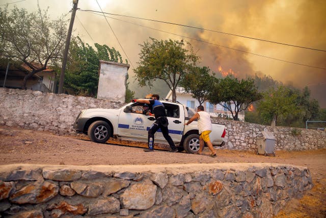 <p>People escape an advancing fire in Cokertme village in Bodrum </p>