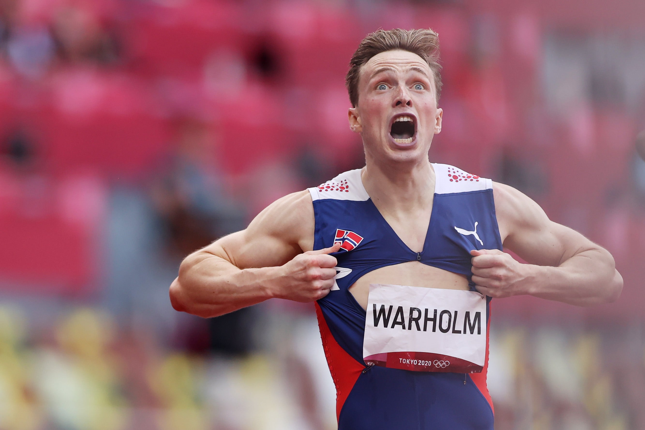 Karsten Warholm rips open his shirt after wining gold