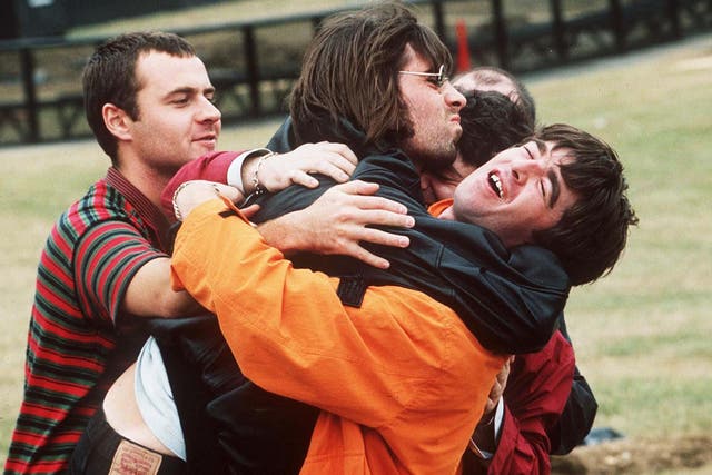 <p>Alan White, Liam Gallagher, Noel Gallagher in a group hug with fellow Oasis members  Paul ‘Guigsy’ McGuigan and Paul ‘Bonehead’ Arthurs before their show at Knebworth, 1996</p>