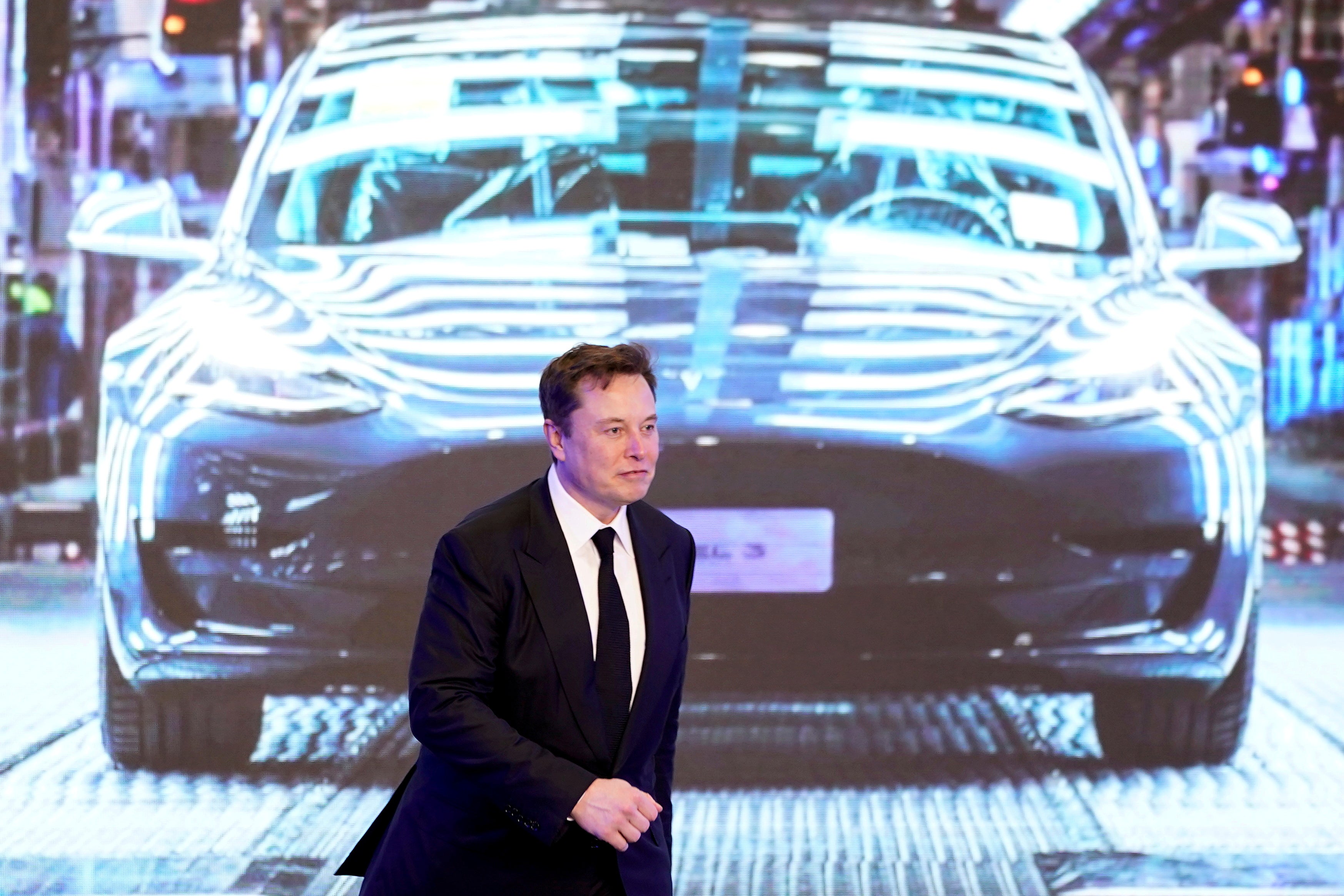 File image: Tesla Inc CEO Elon Musk walks next to a screen showing an image of Tesla Model 3 car during an opening ceremony for Tesla China-made Model Y program in Shanghai, China, 7 January 2020