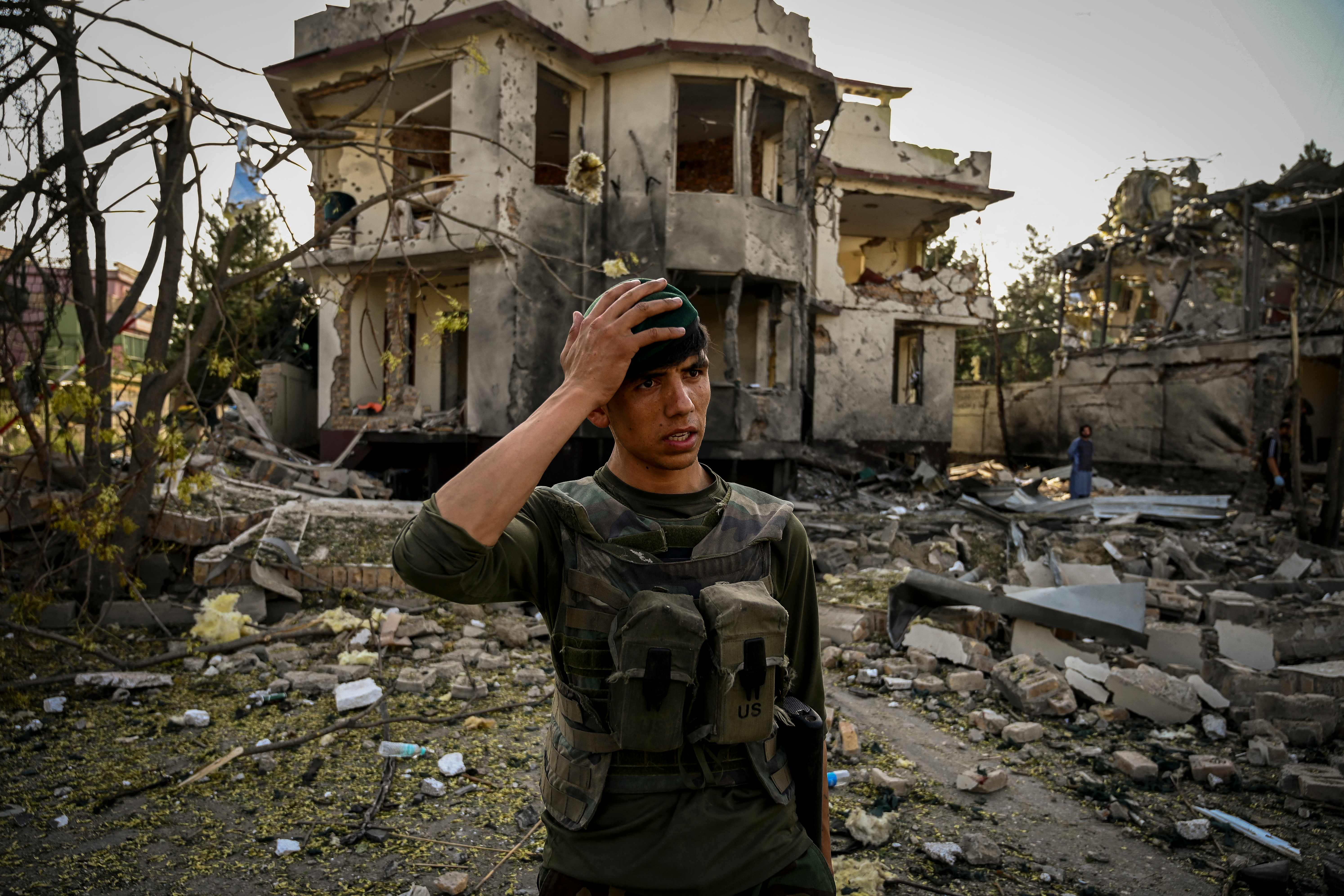 An Afghan security personnel stands guard at the site of the bombing