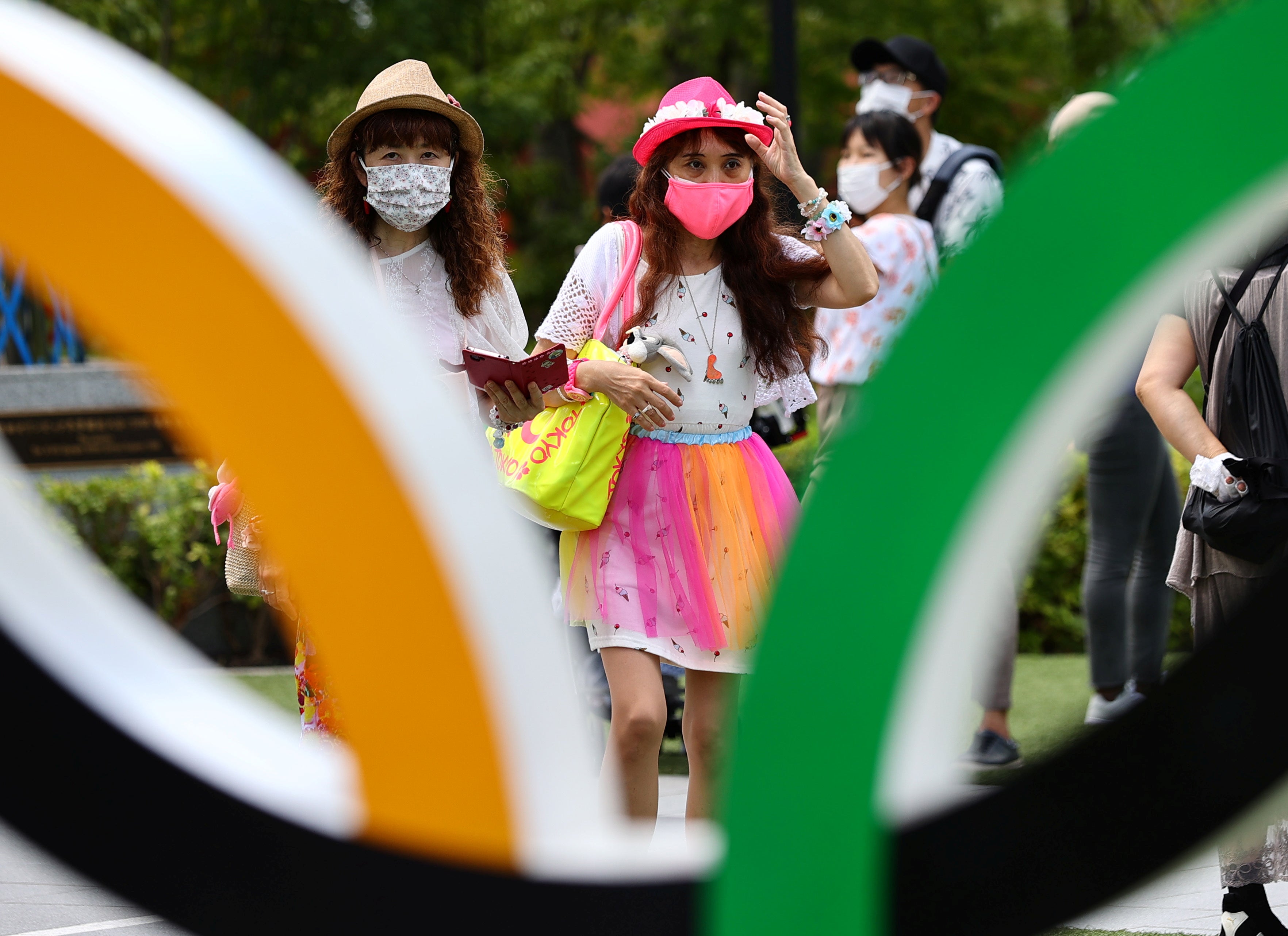 People wearing protective face masks amid the coronavirus disease outbreak visit an Olympic Ring outside the National Stadium, the main venue of the Tokyo 2020 Olympic Games