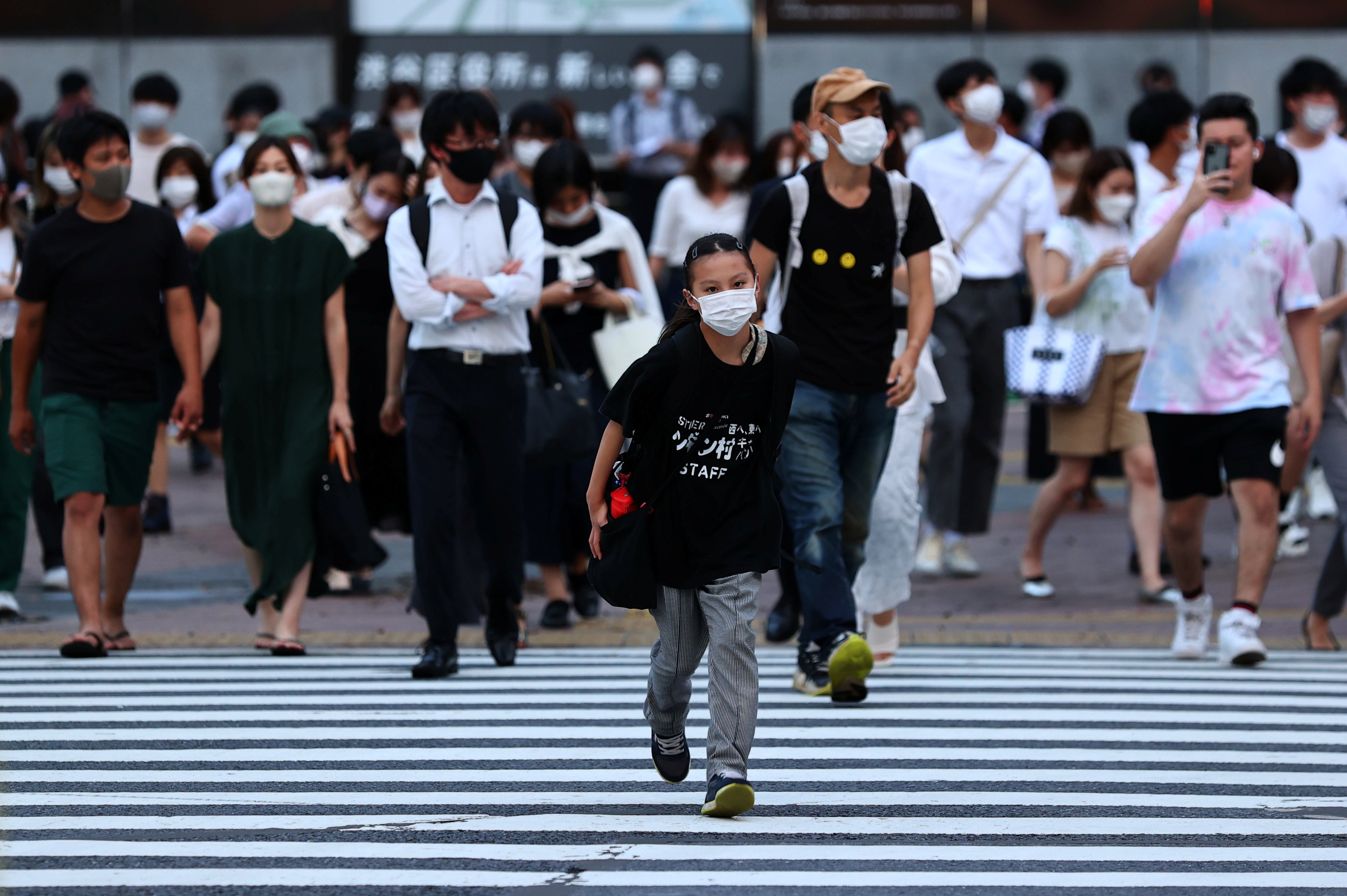 Pedestrians wearing protective masks amid the coronavirus disease (COVID-19) outbreak, walks on crosswalk in Tokyo