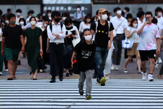 <p>Pedestrians wearing protective masks amid the coronavirus disease (COVID-19) outbreak, walks on crosswalk in Tokyo</p>