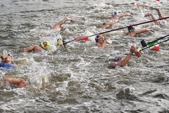 <p>Competitors take refreshments at a feed station in the women's 10km marathon swimming event during the Tokyo 2020 Olympic Games at the Odaiba Marine Park in Tokyo on August 4, 2021.</p>
