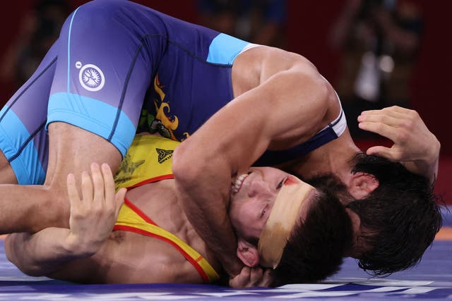 <p>Kazakhstan's Nurislam Sanayev (pinned to the ground) bit into the right bicep of India's Ravi Dahiya as while wrestling him during the men's freestyle 57kg wrestling semi-final</p>