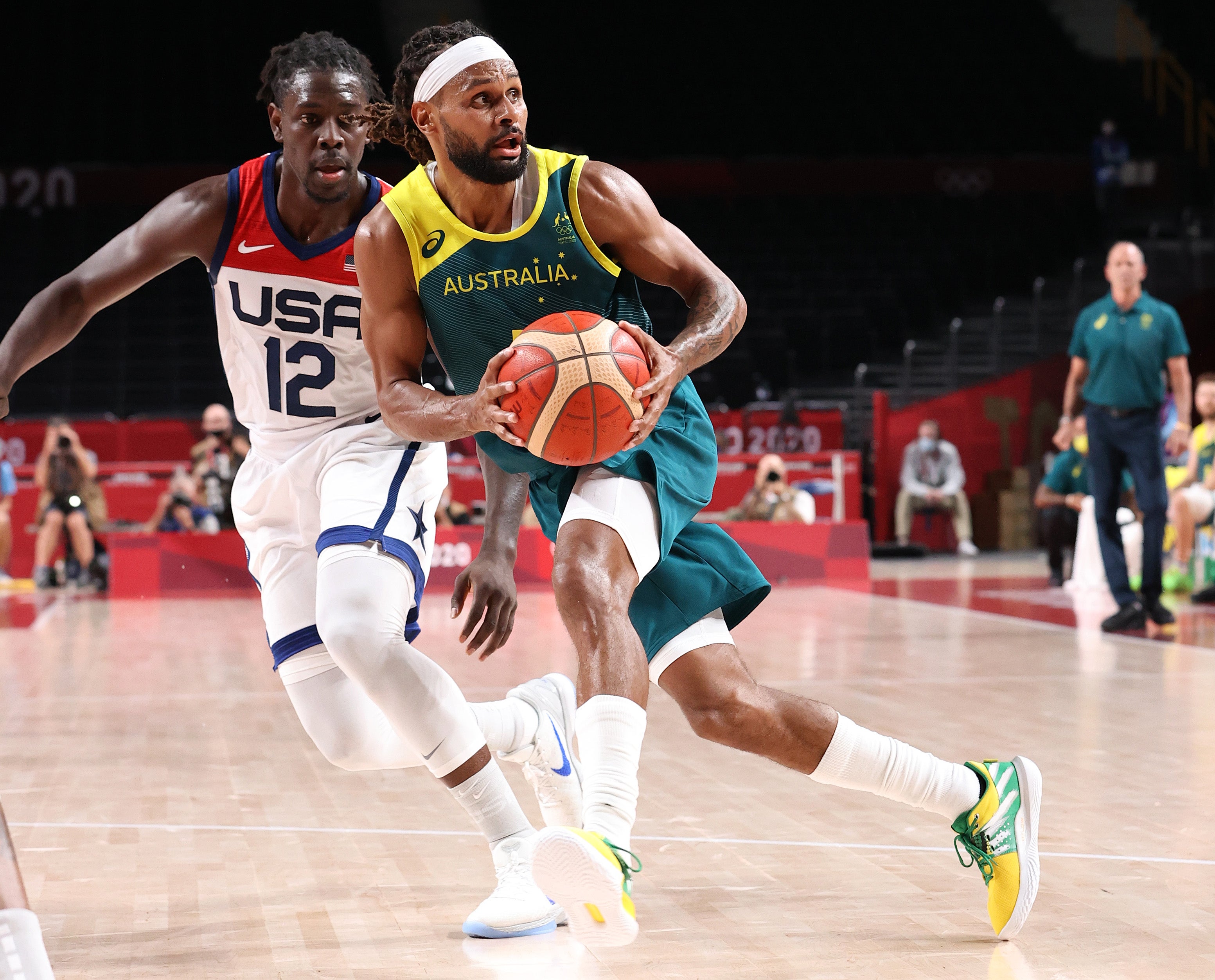 Patty Mills of Team Australia drives to the basket against Jrue Holiday of Team USA